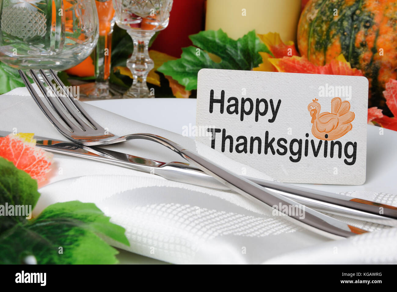 Happy Thanksgiving day card on a plate with a napkin and cutlery on the table Stock Photo