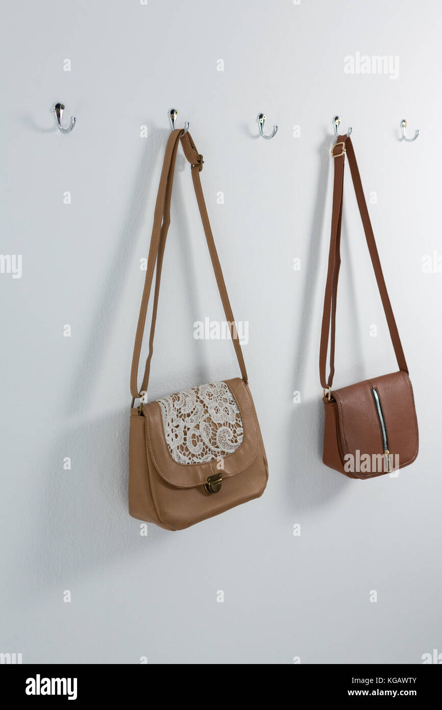 Stylish handbags hanging on hook Stock Photo Alamy