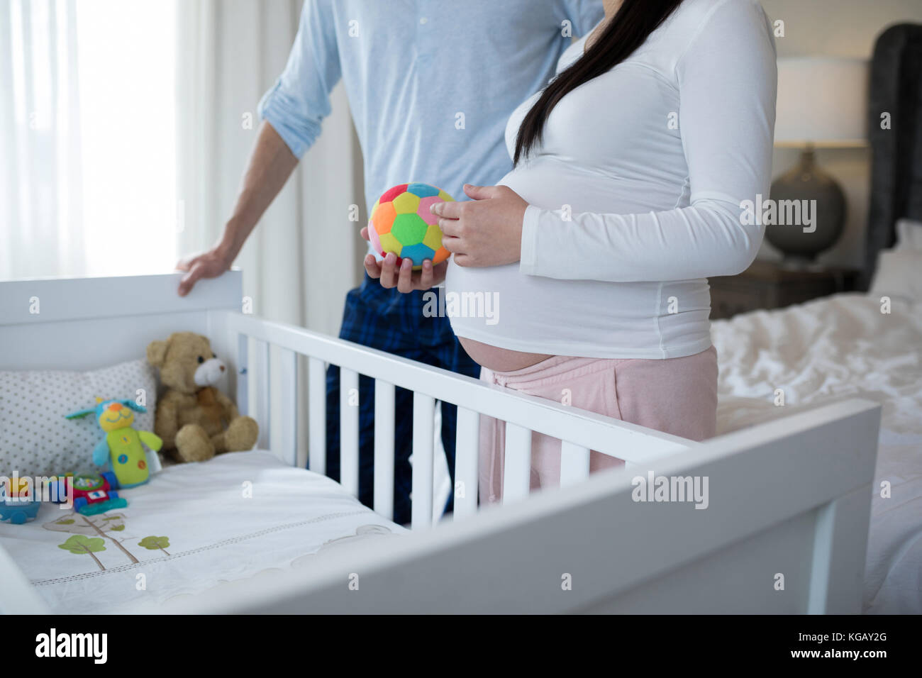 Mid section of couple holding toys in bedroom Stock Photo