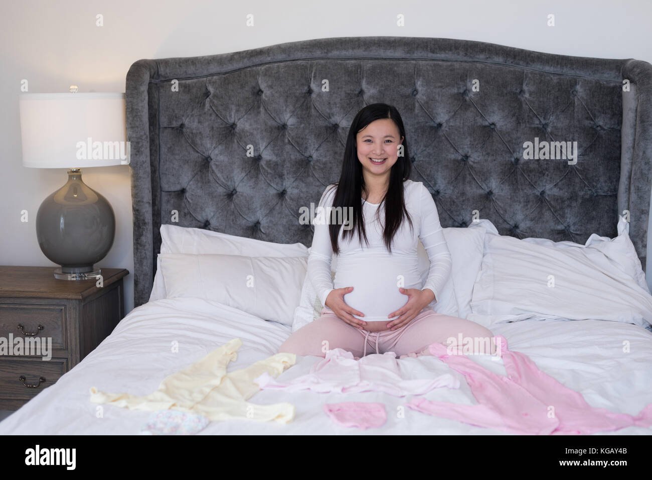 Portrait of woman feeling the presence of baby in stomach at home Stock Photo