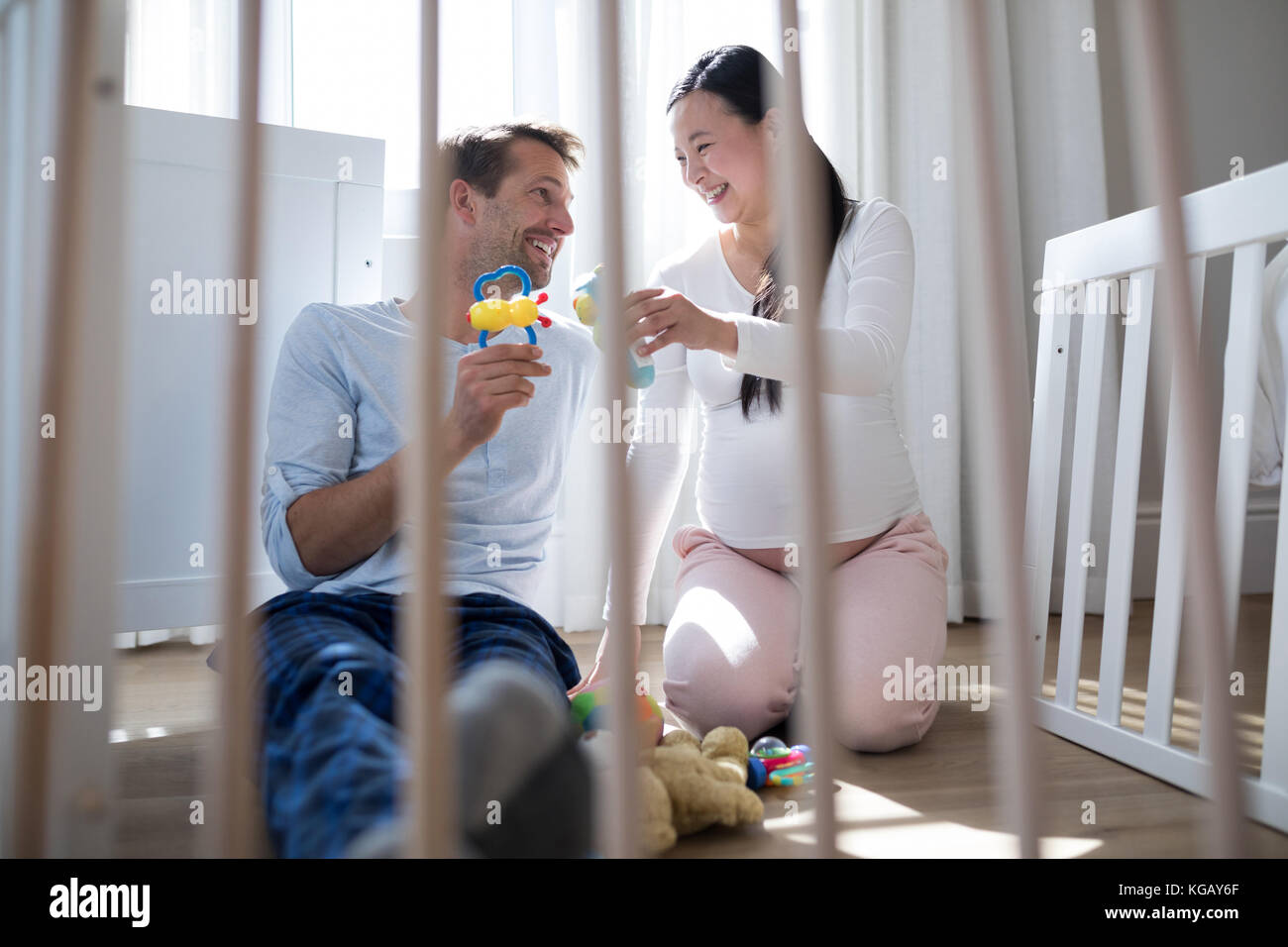 Happy couple playing with toys in bedroom Stock Photo