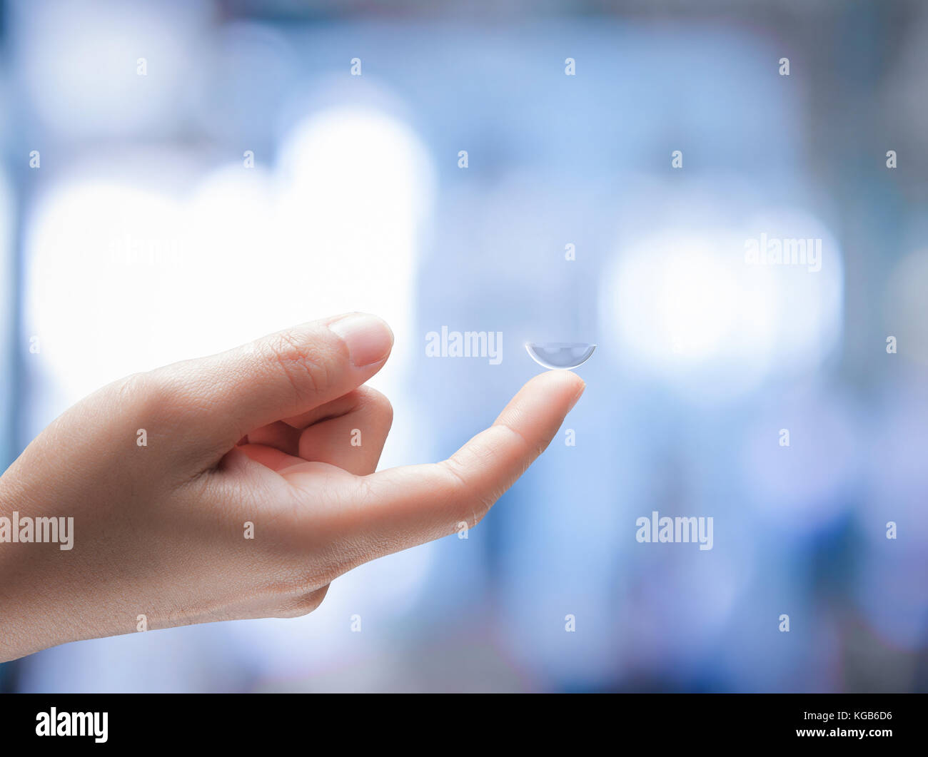 human hand holding contact len on blurred background Stock Photo