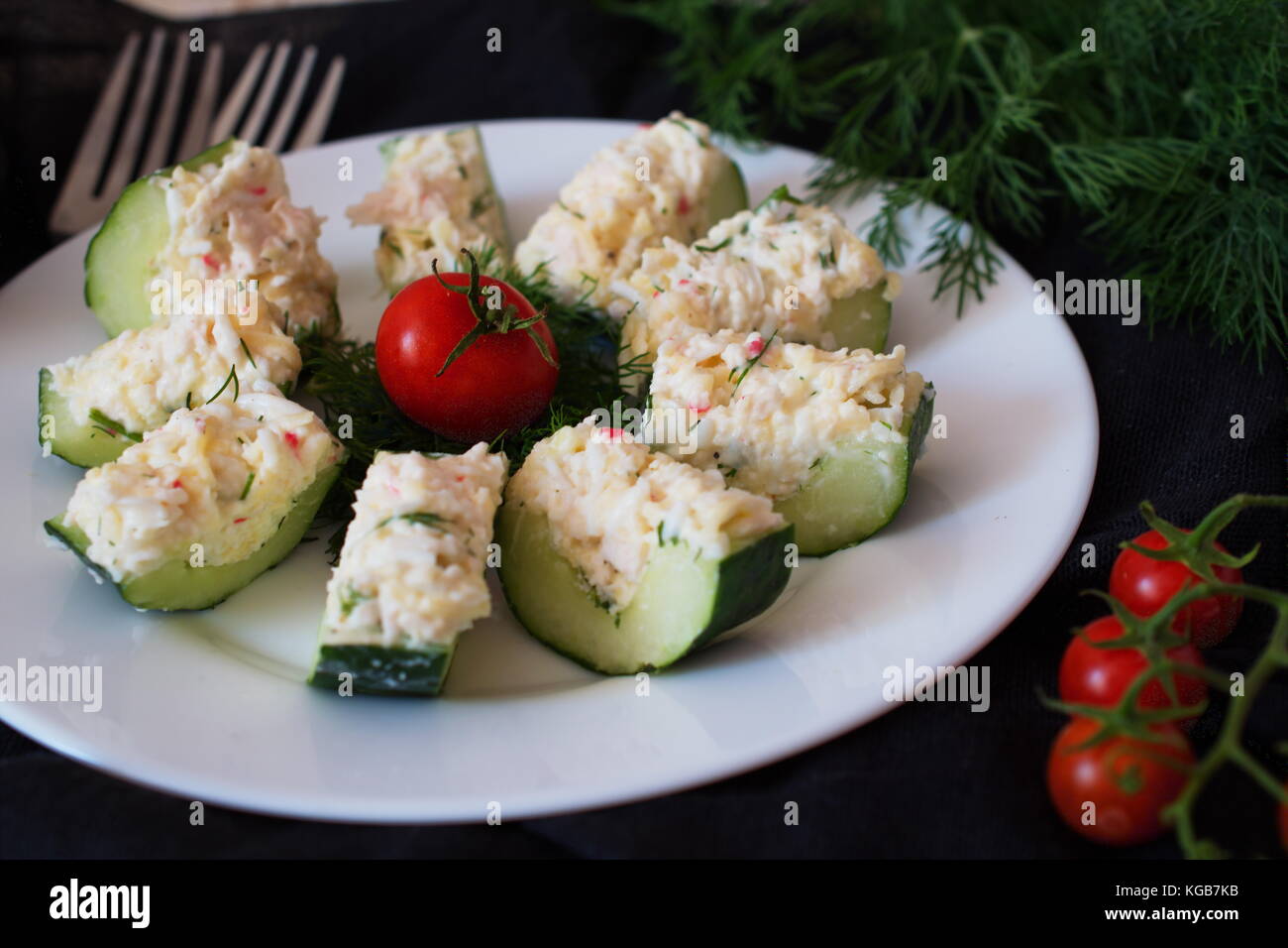 Appetizer from a fresh cucumber with crab meat, egg, cheese and dill