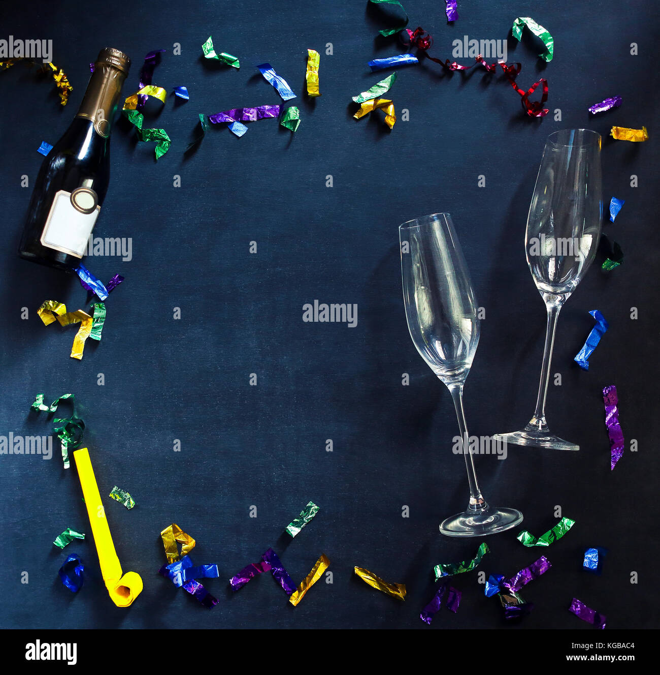 Champagne bottle and glasses on black background with multicolored
