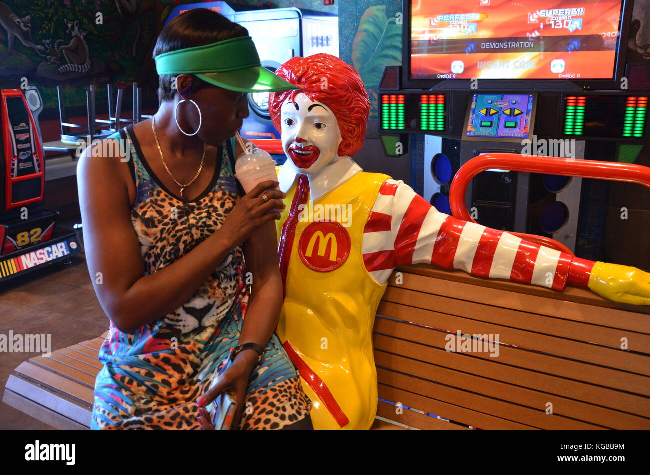 Woman sitting on the lap of statue at McDonald’s on International Drive, Orlando Stock Photo