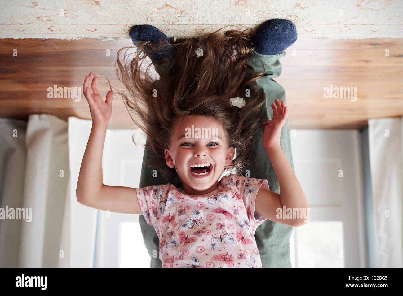 Girl being held upside down by her dad at home, low section Stock Photo