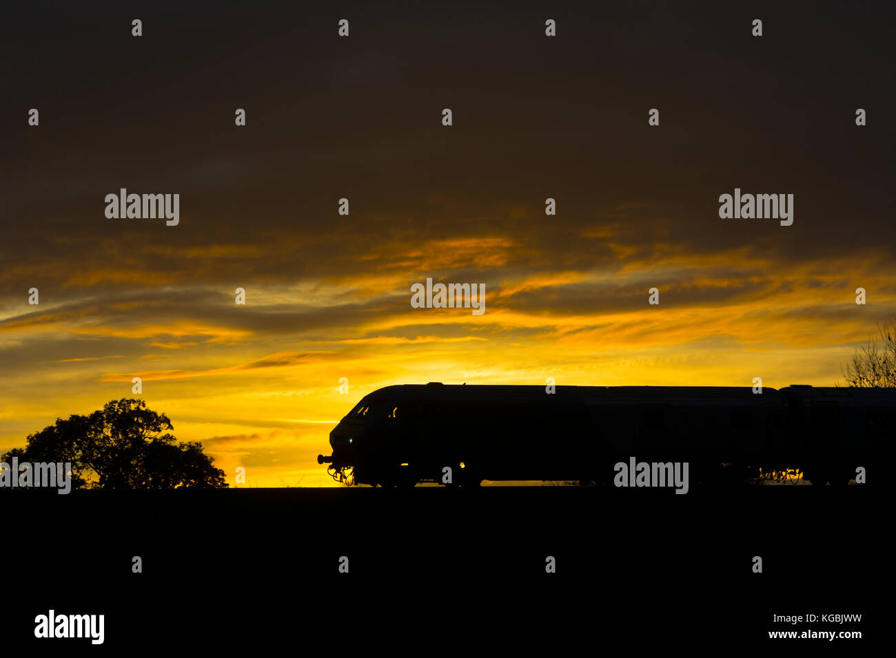 Warwick, Warwickshire, England, UK. 6th November 2017. A Chiltern Railways service to London Marylebone is silhouetted at sunset as it approaches Warwick Parkway station. Credit: Colin Underhill/Alamy Live News Stock Photo