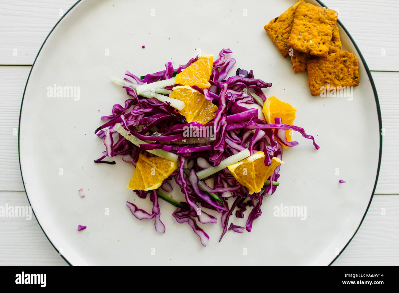 Red cabbage salad with orange on white dish selective focus Stock Photo