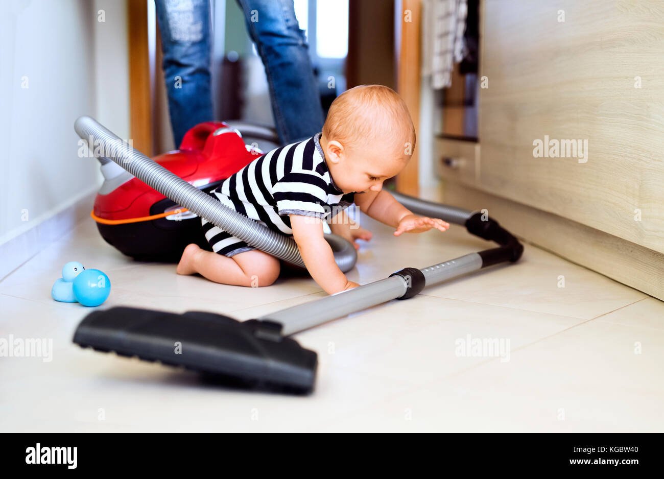 Young mother with a baby boy doing housework Stock Photo - Alamy