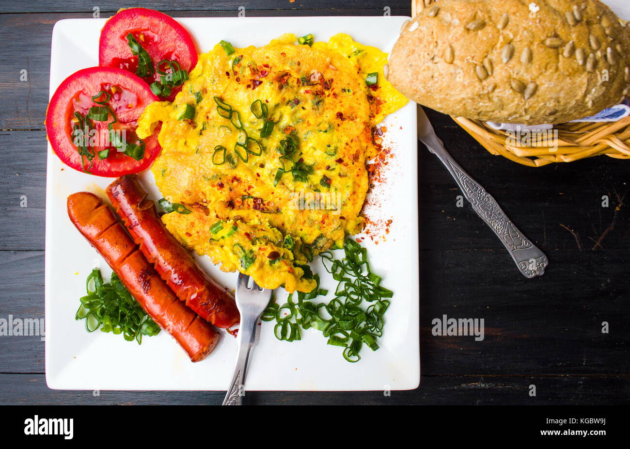 Sausage with scrambled eggs and vegetables on a plate Stock Photo - Alamy