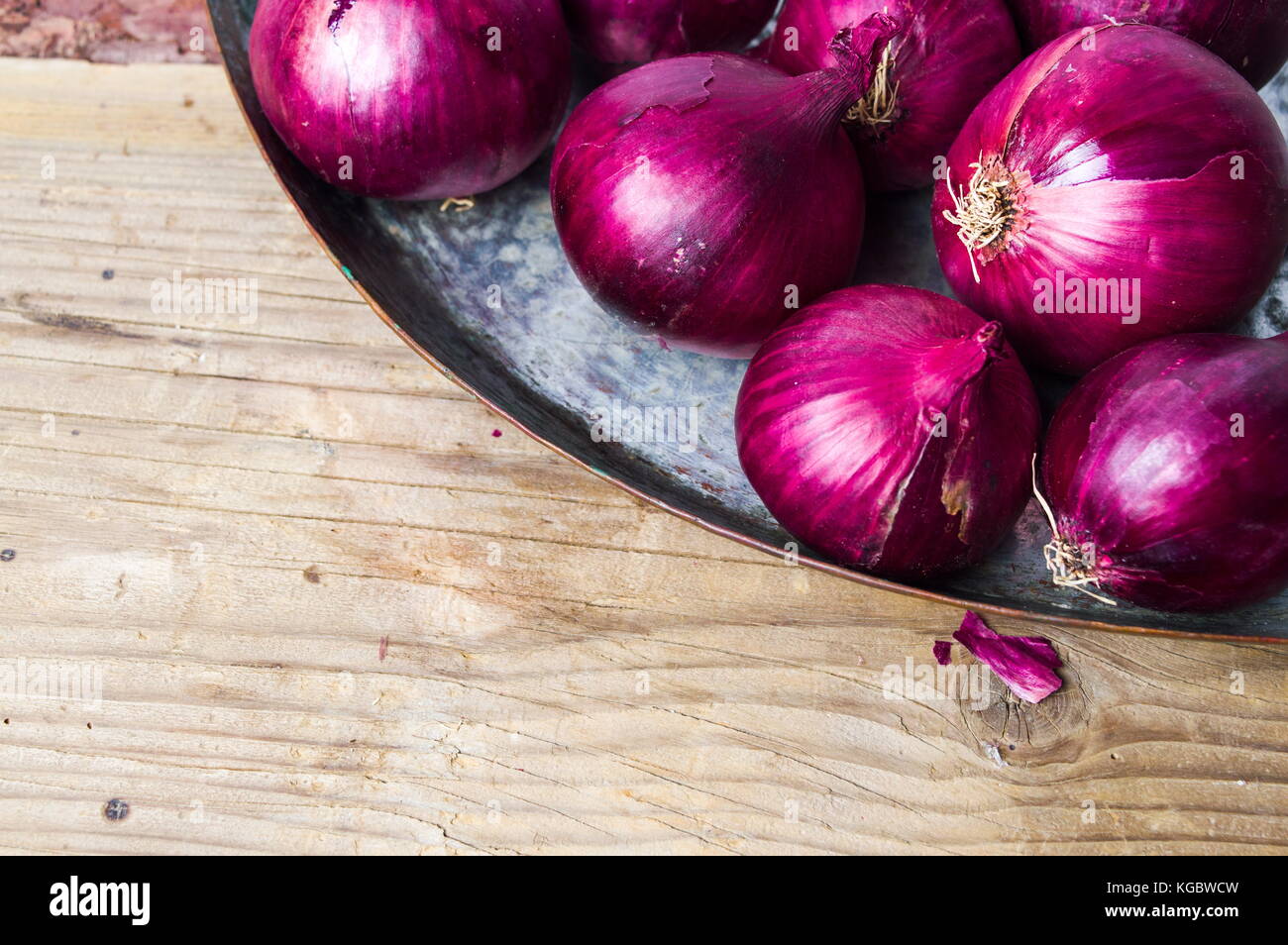 Purple onions on the metal plate with copyspace Stock Photo