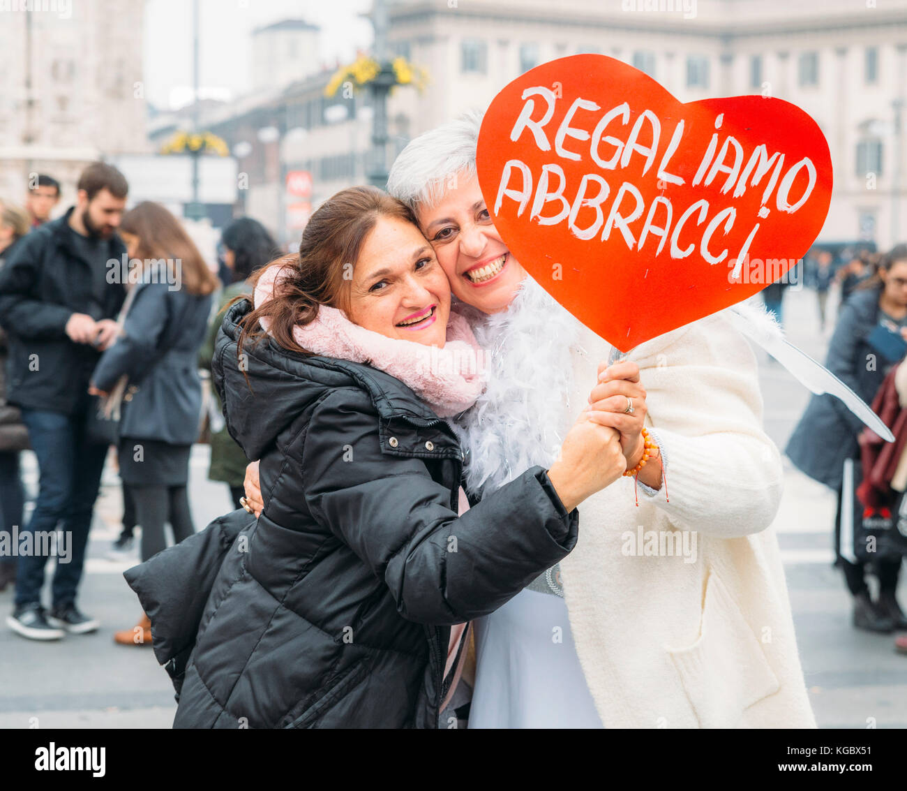 Women dressed as angels giving 'free hugs' to strangers at Milan's Piazza Duomo Stock Photo