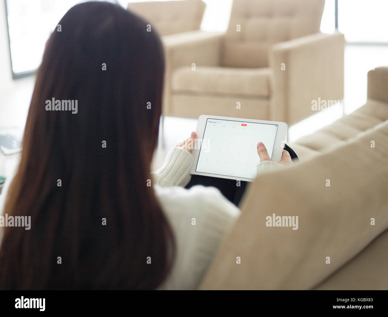 young happy asian woman sitting on sofa using Digital Tablet Stock ...