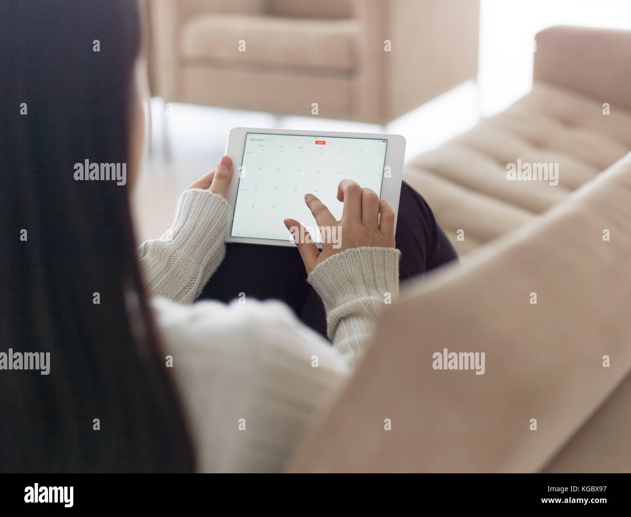 young happy asian woman sitting on sofa using Digital Tablet Stock ...