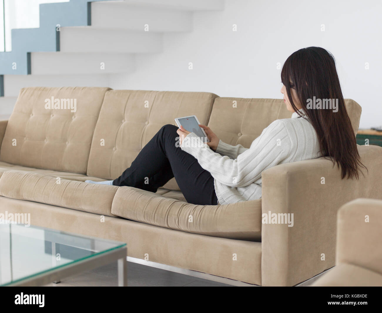 young happy asian woman sitting on sofa using Digital Tablet Stock ...