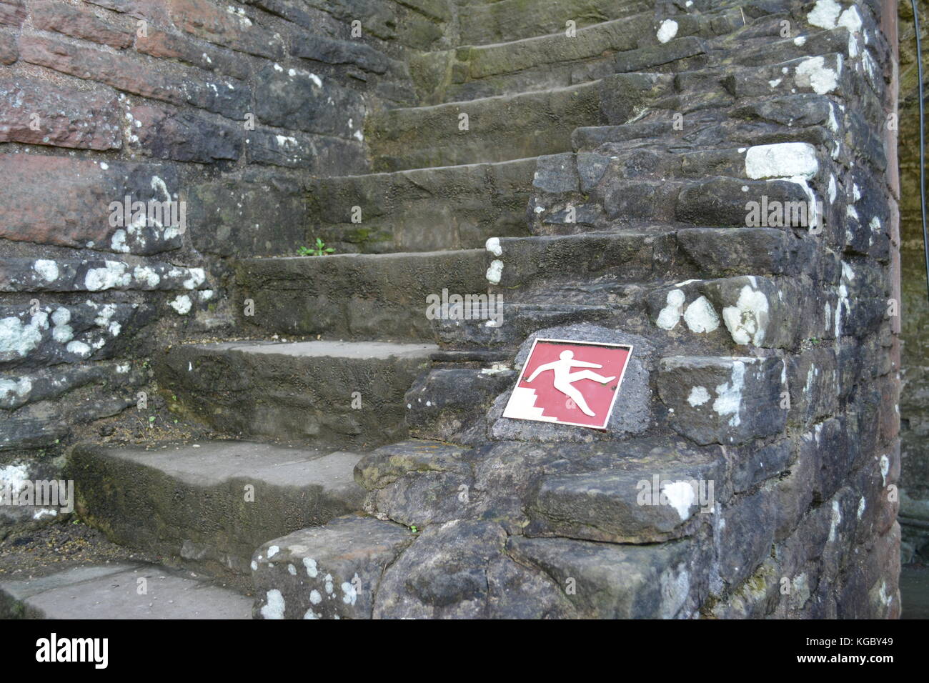 Step stair detail at Tintern Abbey Monmouthshire with red and white square metal danger of falling sign re health and safety hazards ancient structure Stock Photo