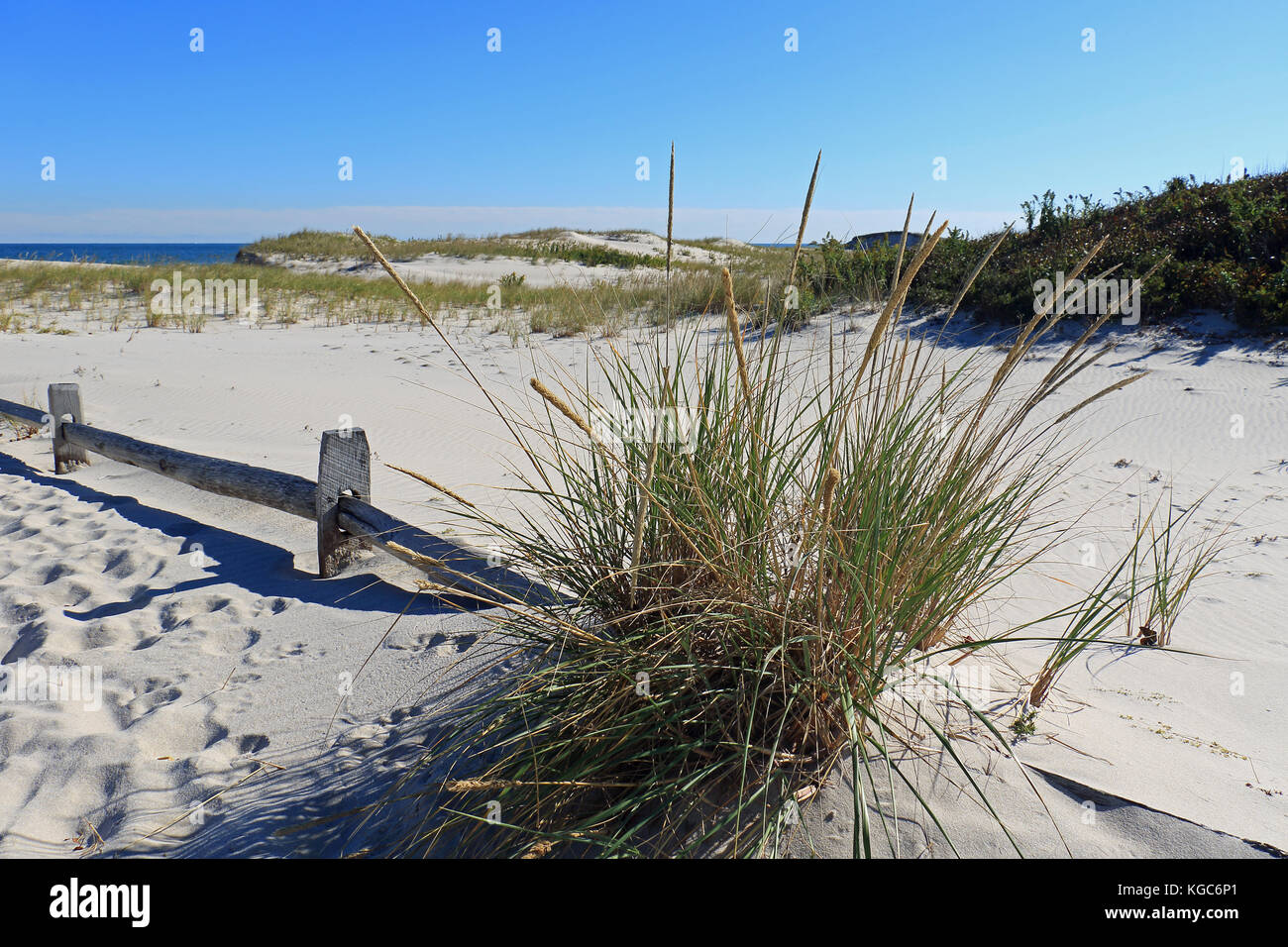 A classic weathered wooden fence lines the pathway towards to sea and through the many pristine dunes of this unspoiled Jersey Shore beach Stock Photo