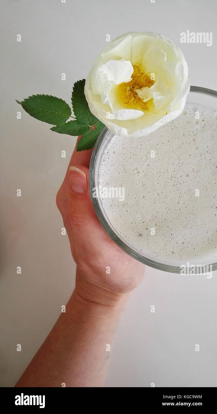 Self-made almond milk on the table together with a Midsummer rose Stock Photo