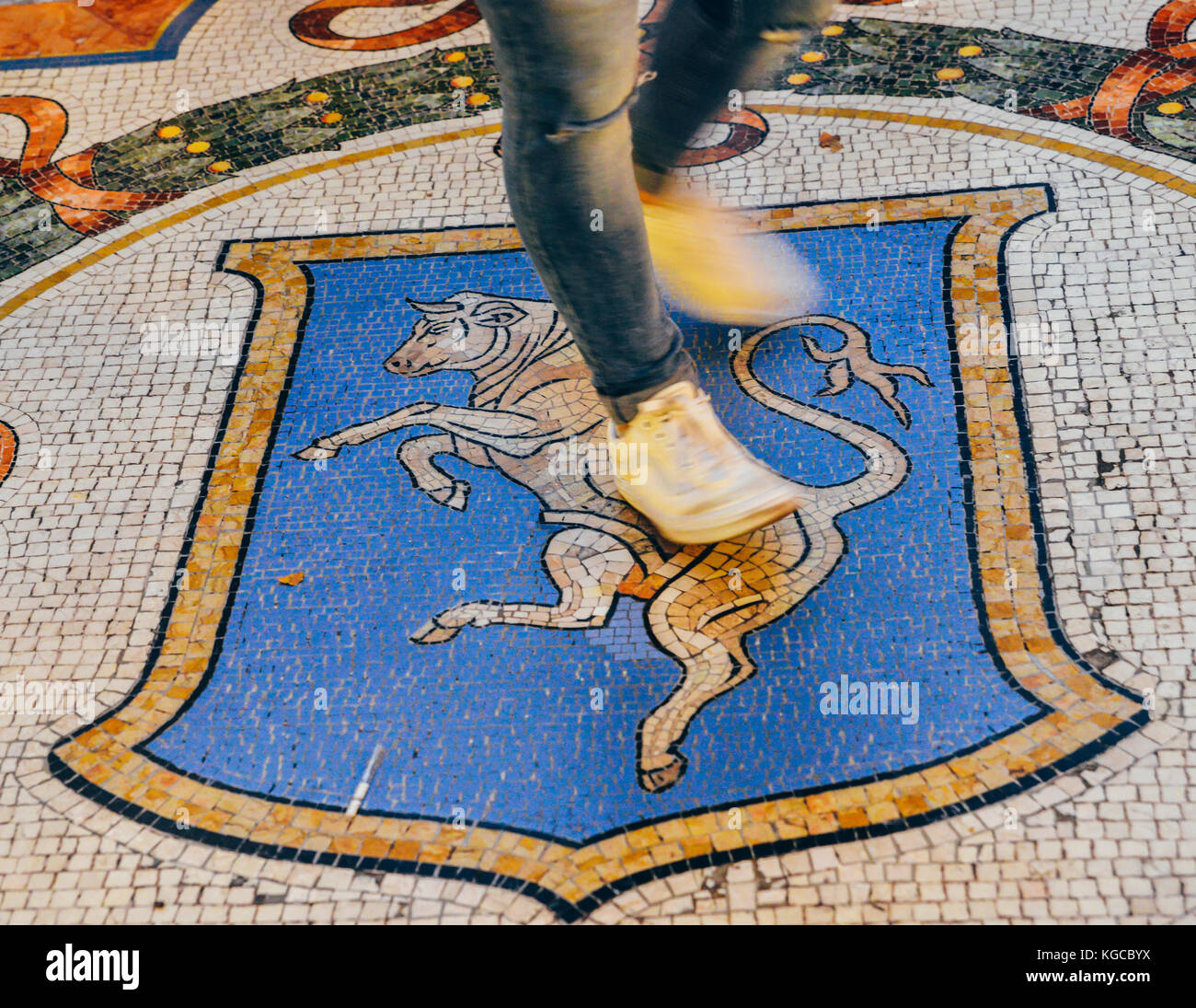 At Milan's Vittorio Emanuelle II Gallery, the tradition is that if a person puts their right heel on the bull’s testicles brings good luck Stock Photo