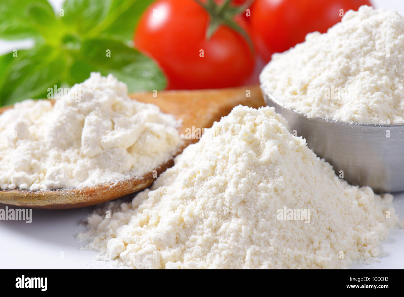 detail of soft wheat flour on wooden spoon and in metal bowl Stock Photo