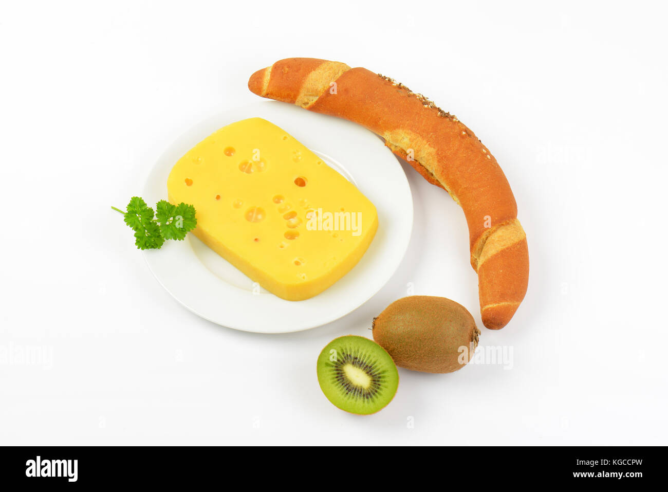 block of cheese, kiwi and fresh bread roll on white background Stock Photo