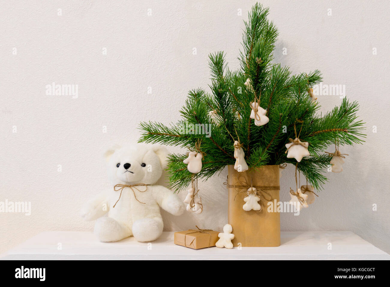 Christmas pine branch in vase with homemade cookies white bear. decor in  Scandinavian style, white background Stock Photo - Alamy