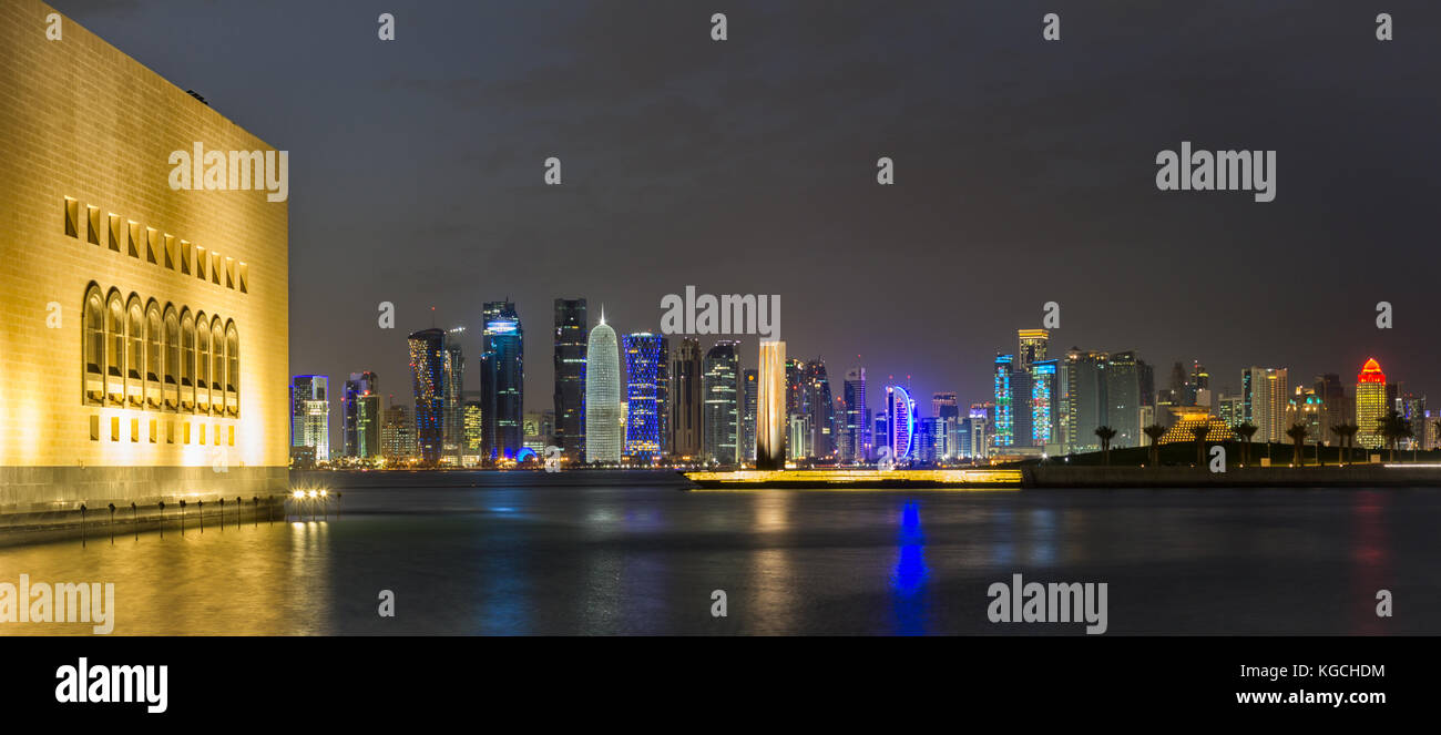 Doha Qatar skyline at night showing skyscrapers lights reflected in the