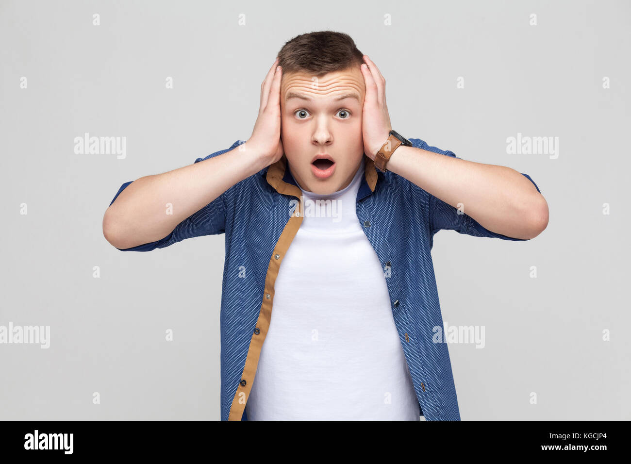 Fear concept. Young man open mouth and have a big eyes. Indoor shot