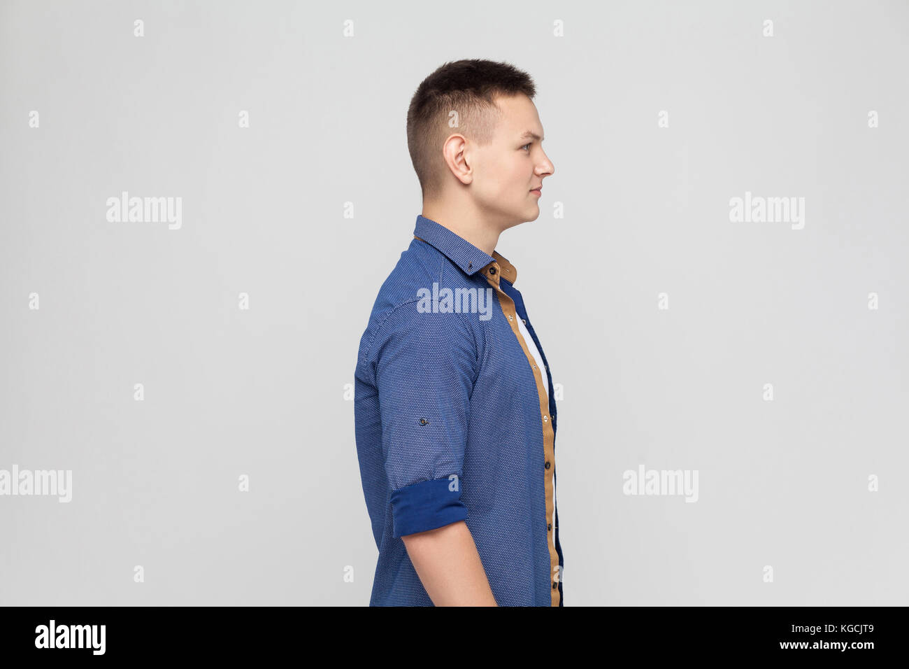 Profile young boy. Standing near gray wall Stock Photo
