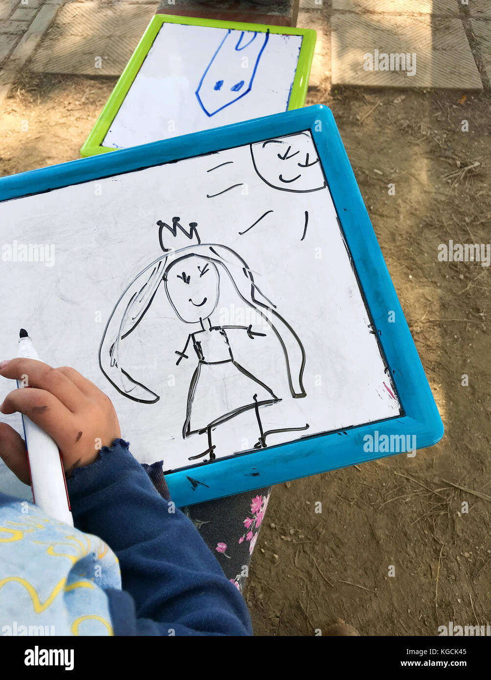 Hands of small student drawing on whiteboards in outdoors Stock Photo