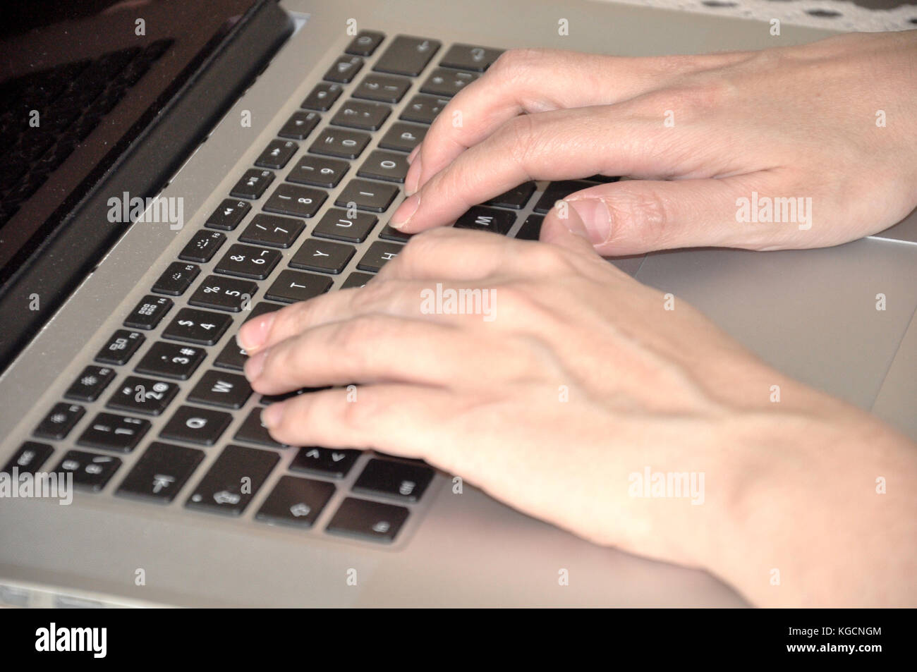 Woman hands over a laptop keyboard Stock Photo