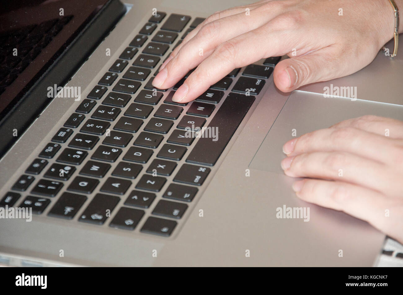 Woman hands using a laptop keyboard Stock Photo