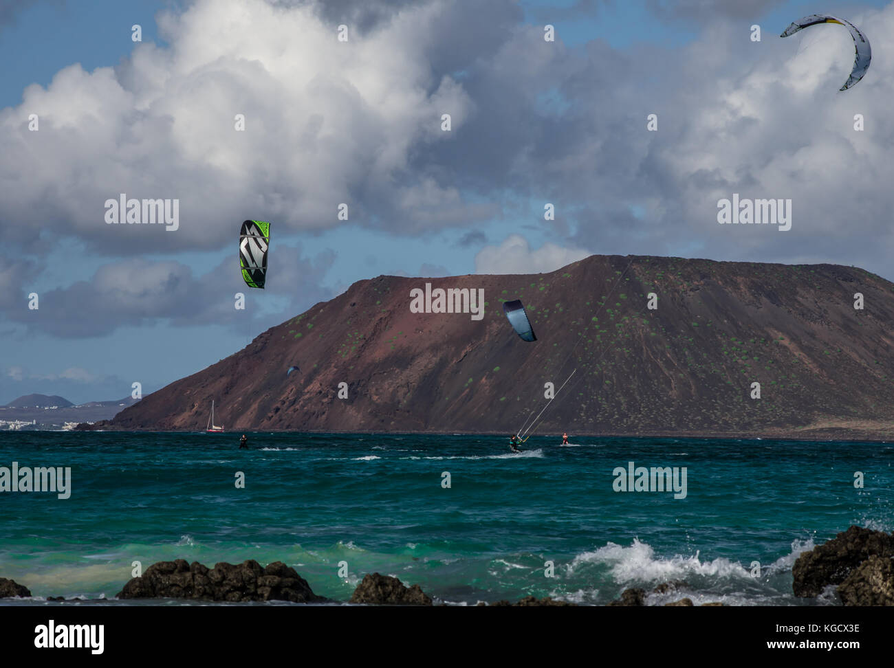 practitioners of kitesurfing in the wilderness of the Canaries, in the sea area between Fuerteventura and los lobos covered by clouds Stock Photo