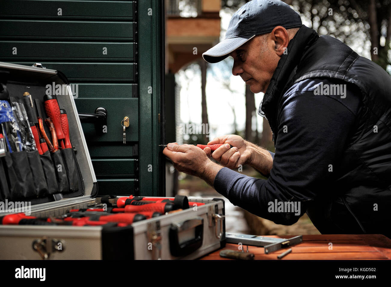 Carpenter Works To Fix The New Lock In The Door Hole Stock