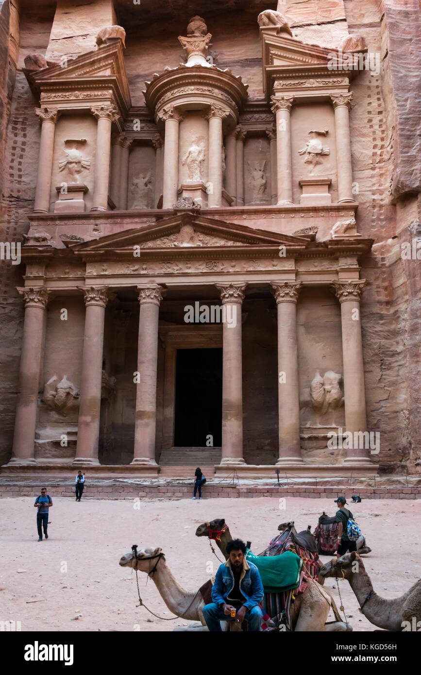 Pink carved sandstone, The Treasury, Al Khazneh, Petra, Jordan, Middle East, with camels and waiting camel driver Stock Photo