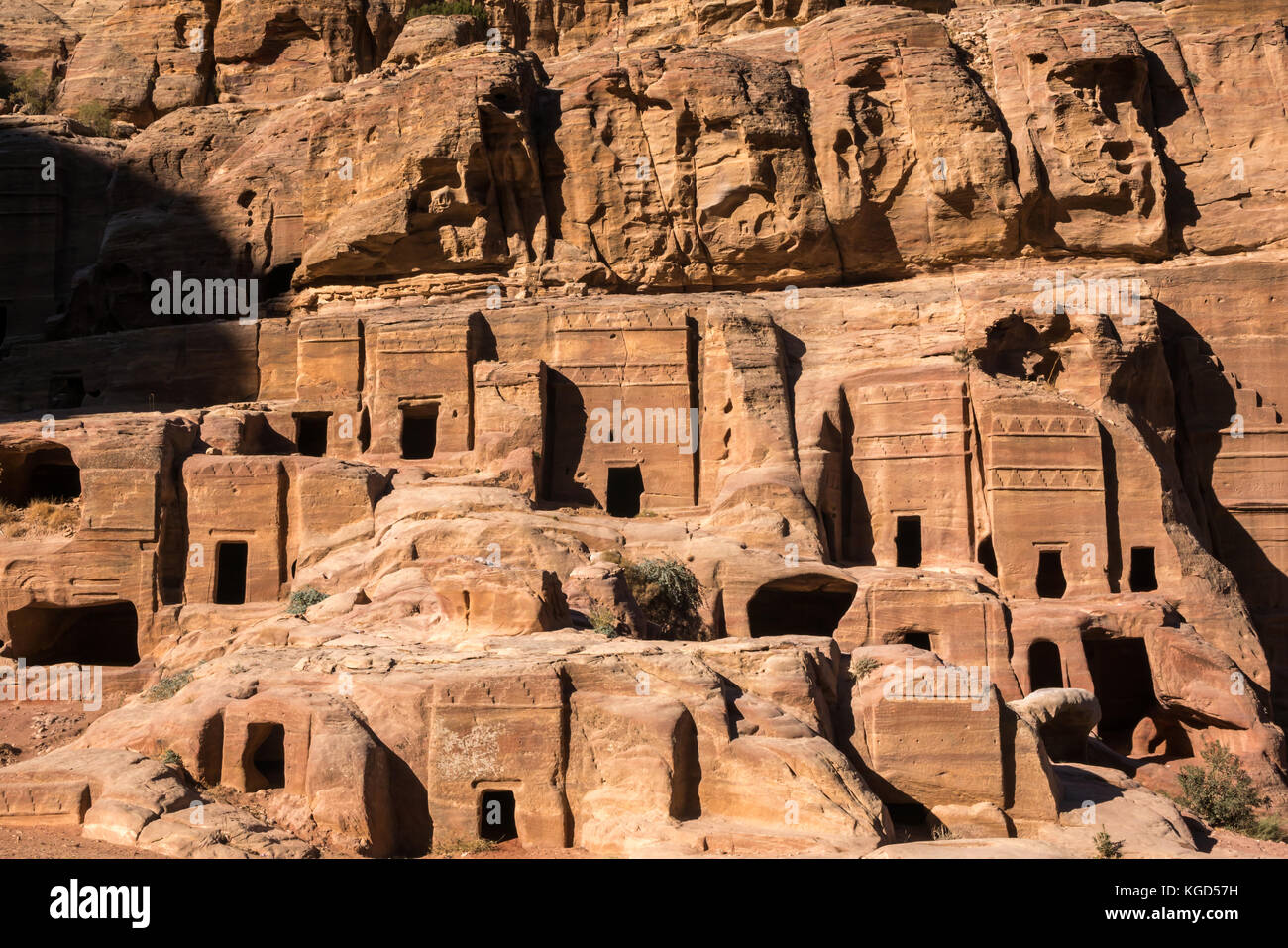 Pink sandstone carved Nabataean tombs, Street of Facades, lit by early morning sun, Petra, Jordan, Middle East Stock Photo