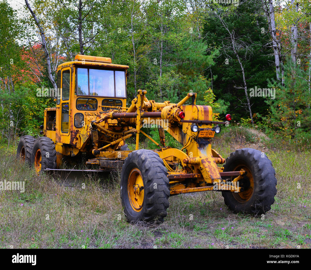 Rusty old road excavator parked in a clearing in the Adirondack wilderness. Stock Photo