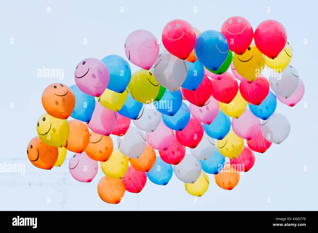 Bunch of vibrant color balloons with smiley face in the sky, Pune, Maharashtra Stock Photo