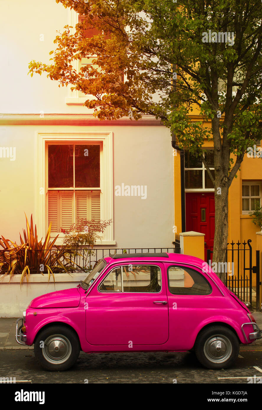 Lateral picture of an old Italian car, a fiat 500 of purple color, the vehicle is parked in the street of Notting Hill in the Centre of the city of Lo Stock Photo