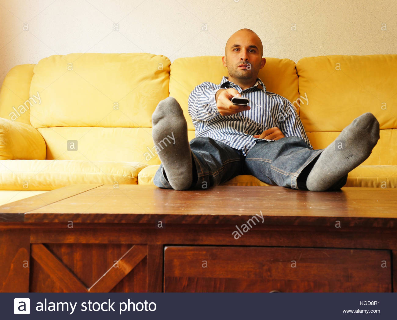 Lazy Man Sitting On The Sofa And Holding A Remote Stock Photo