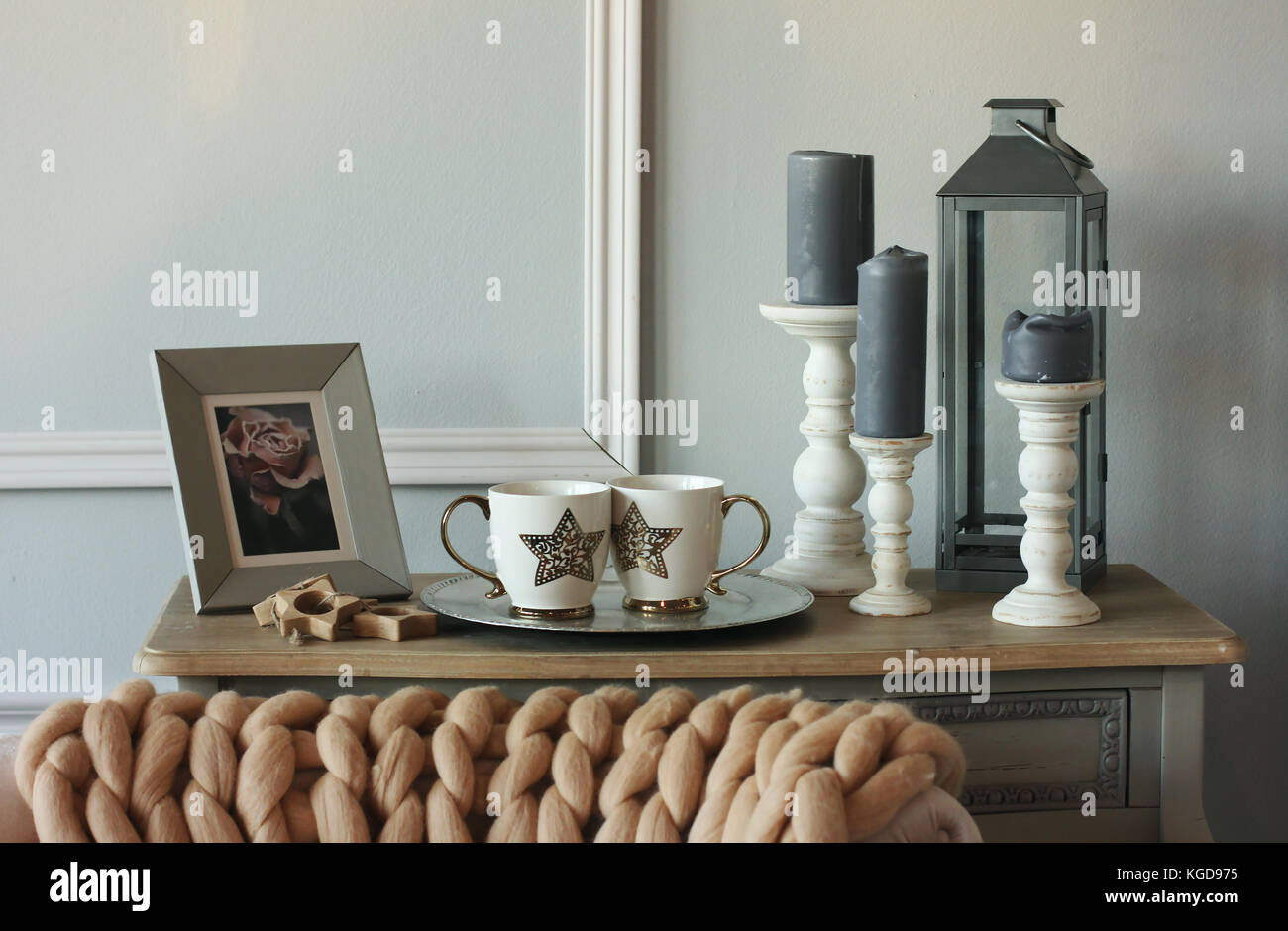 Vintage sofa table with candles, knitted blanket in Scandinavian interior Stock Photo