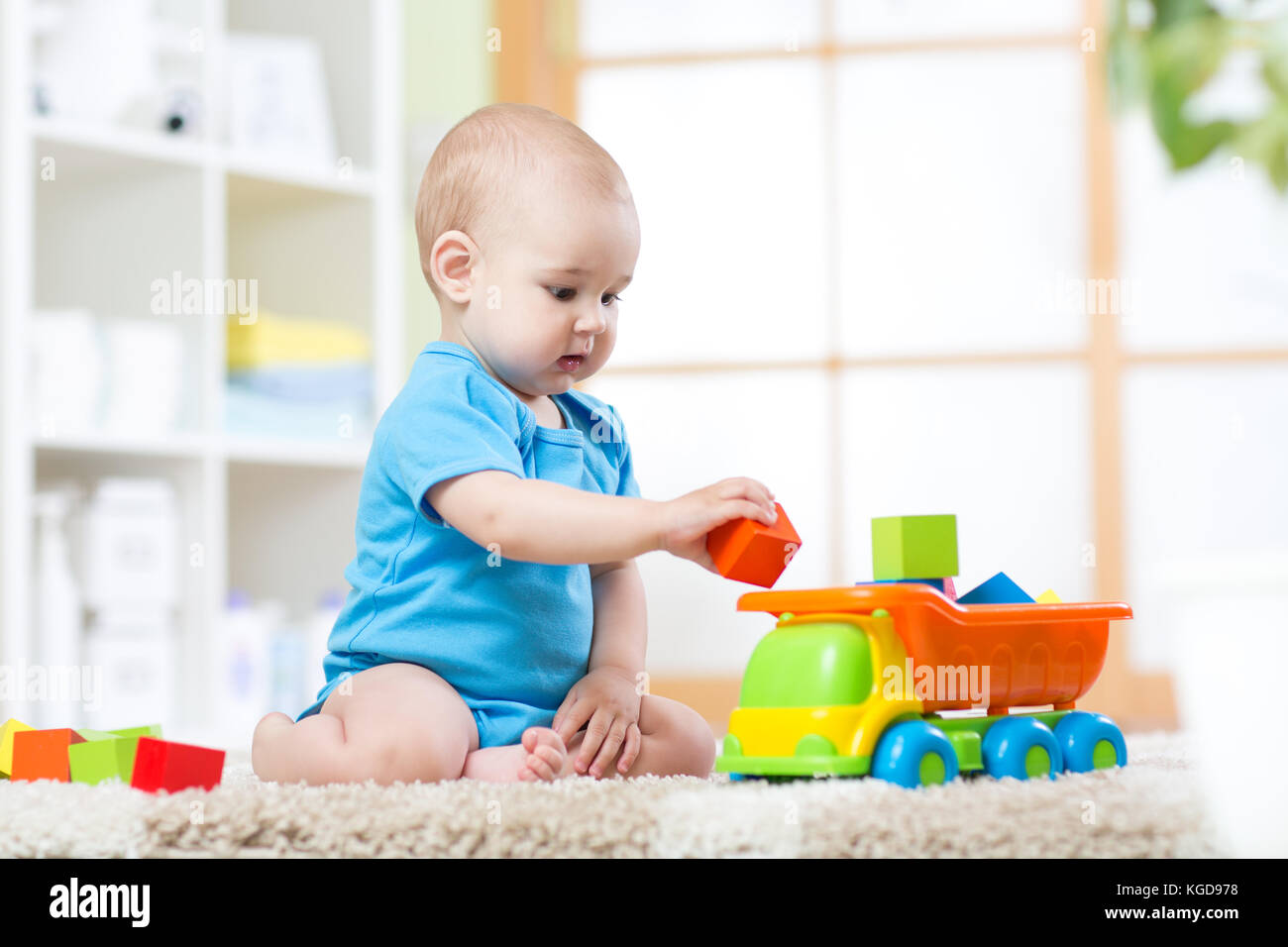 Baby toddler boy playing with toy car Stock Photo