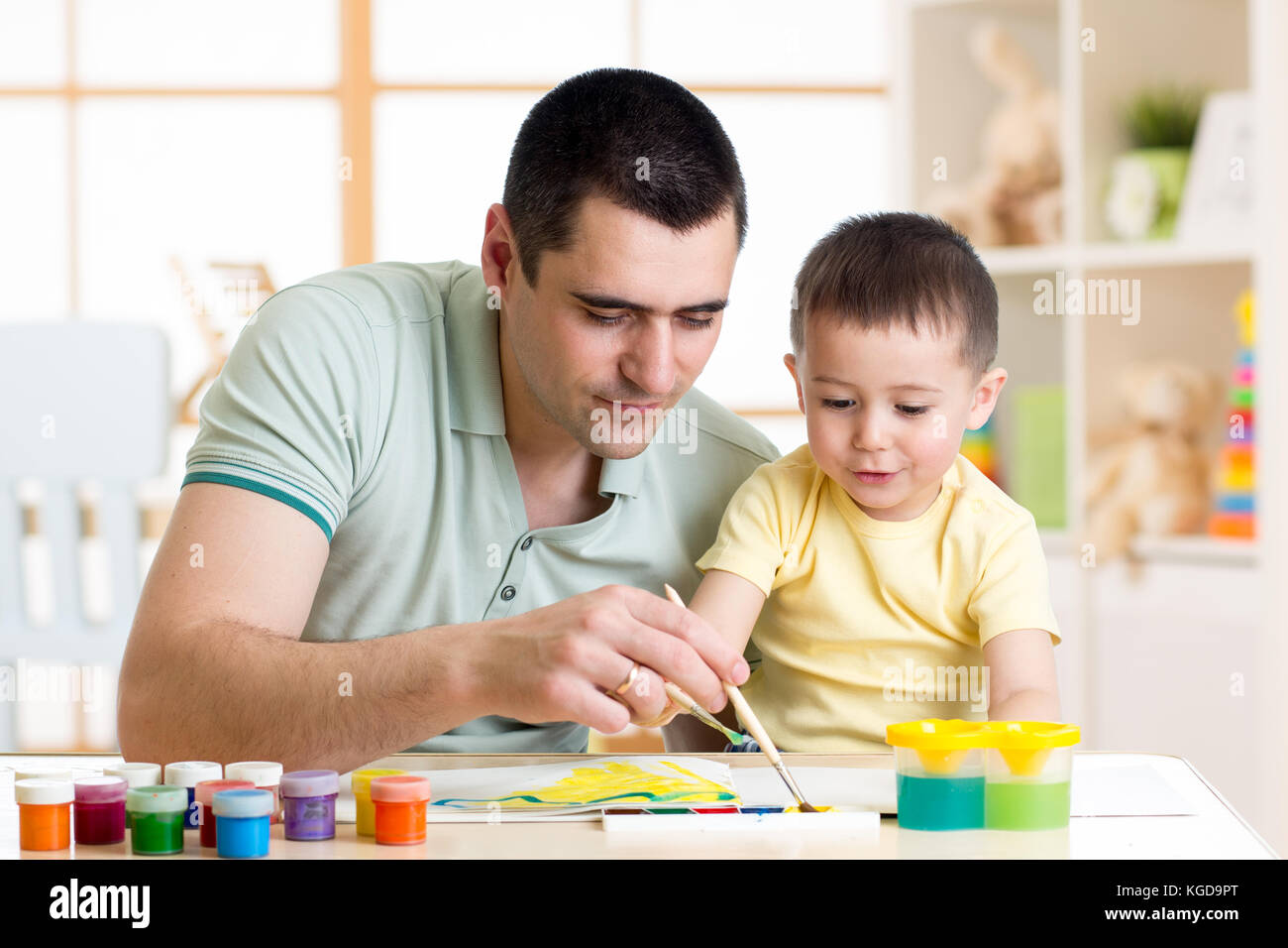 Father and little boy having fun painting at home Stock Photo