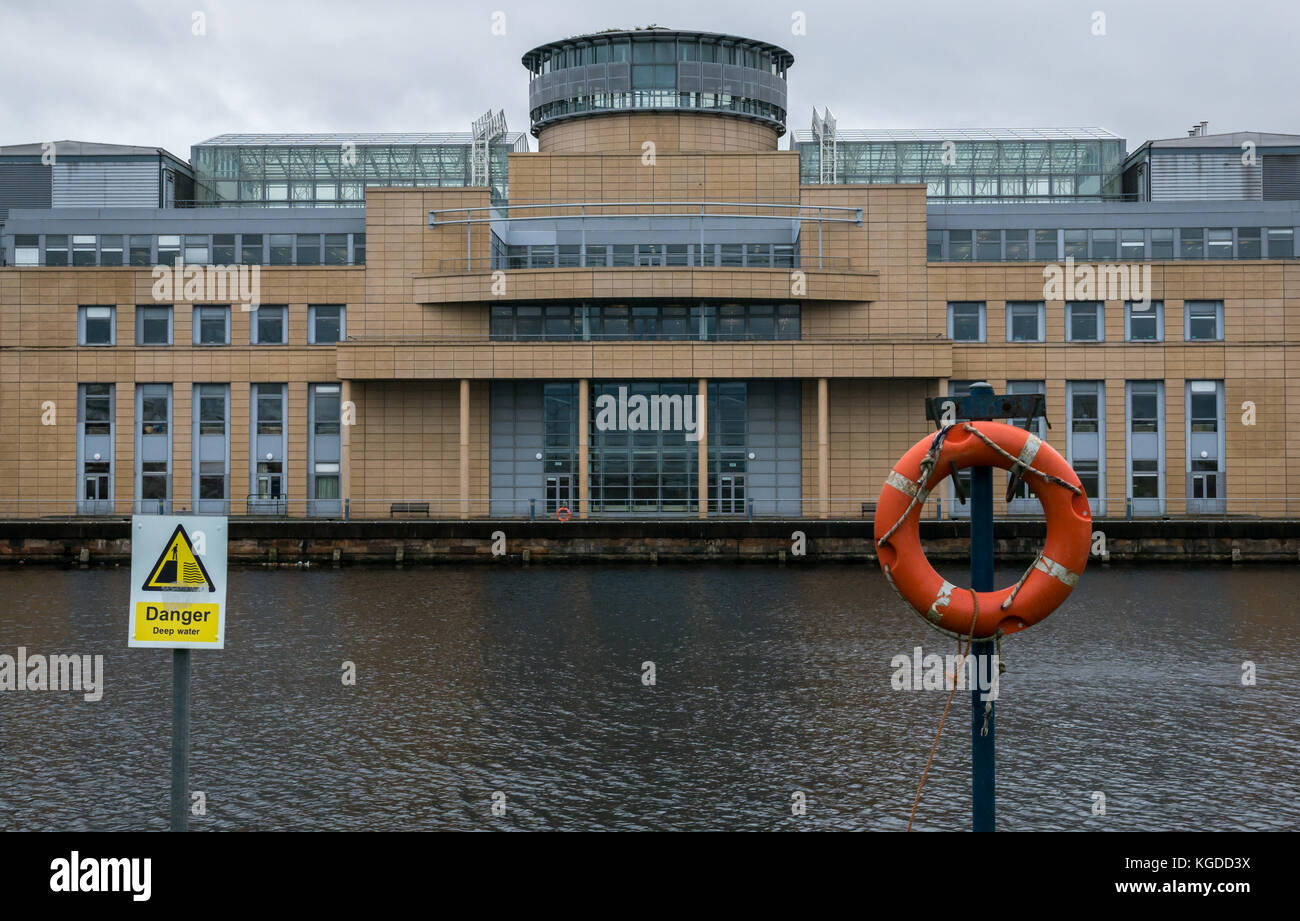 Victoria Quay, Scottish Government office building, Leith, Edinburgh, UK, with lifebelt and triangle danger deep water sign in foreground Stock Photo