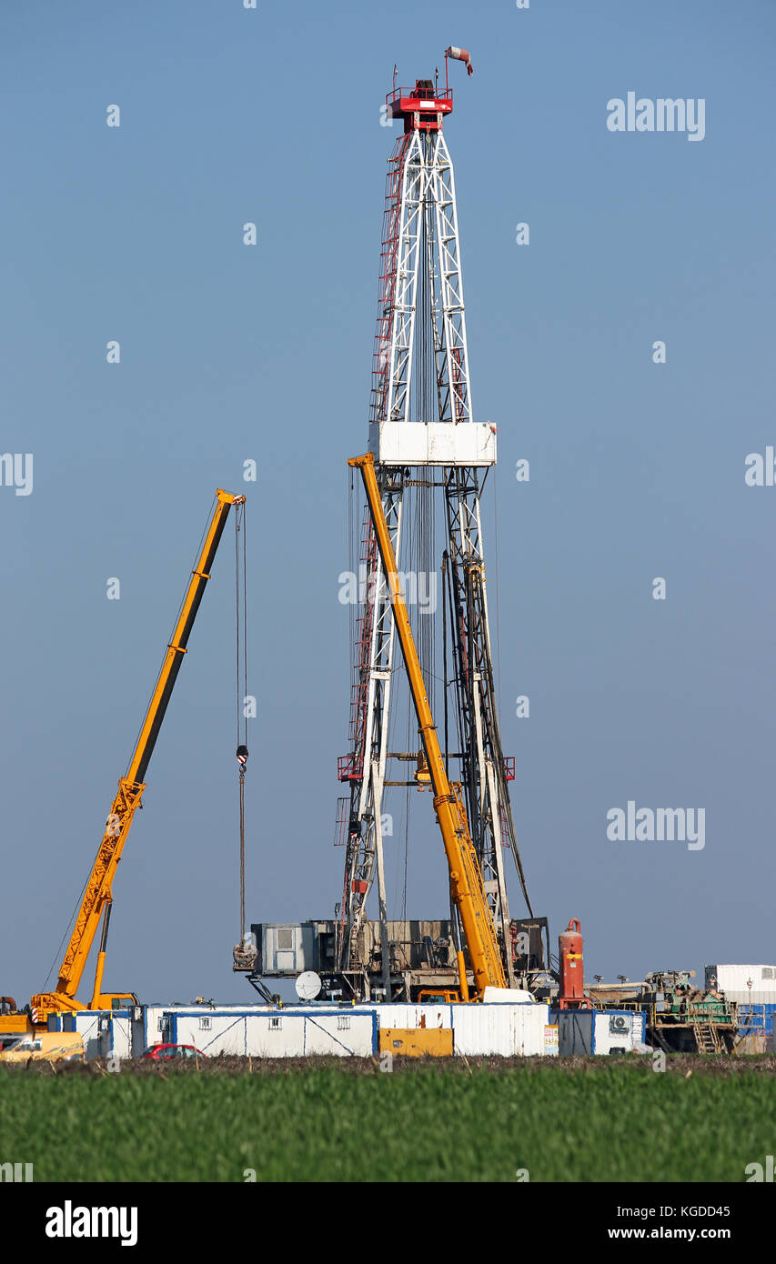 oil drilling rig and cranes on oilfield Stock Photo