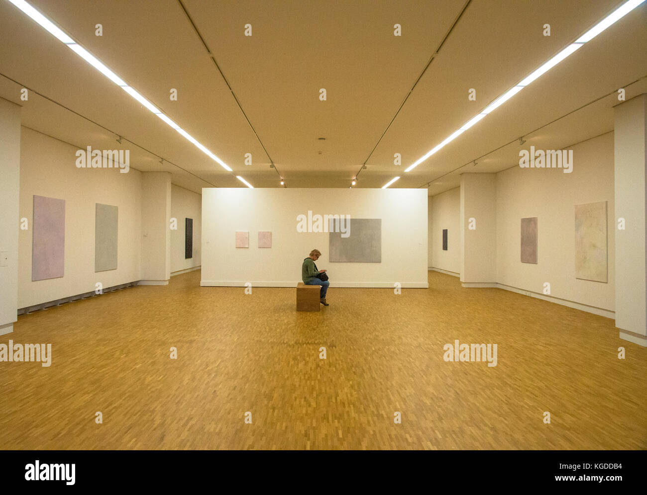 one vistor sitting in room with exposition of paintings of Maaike Schoorel at museum  in Den Haag, Holland Stock Photo