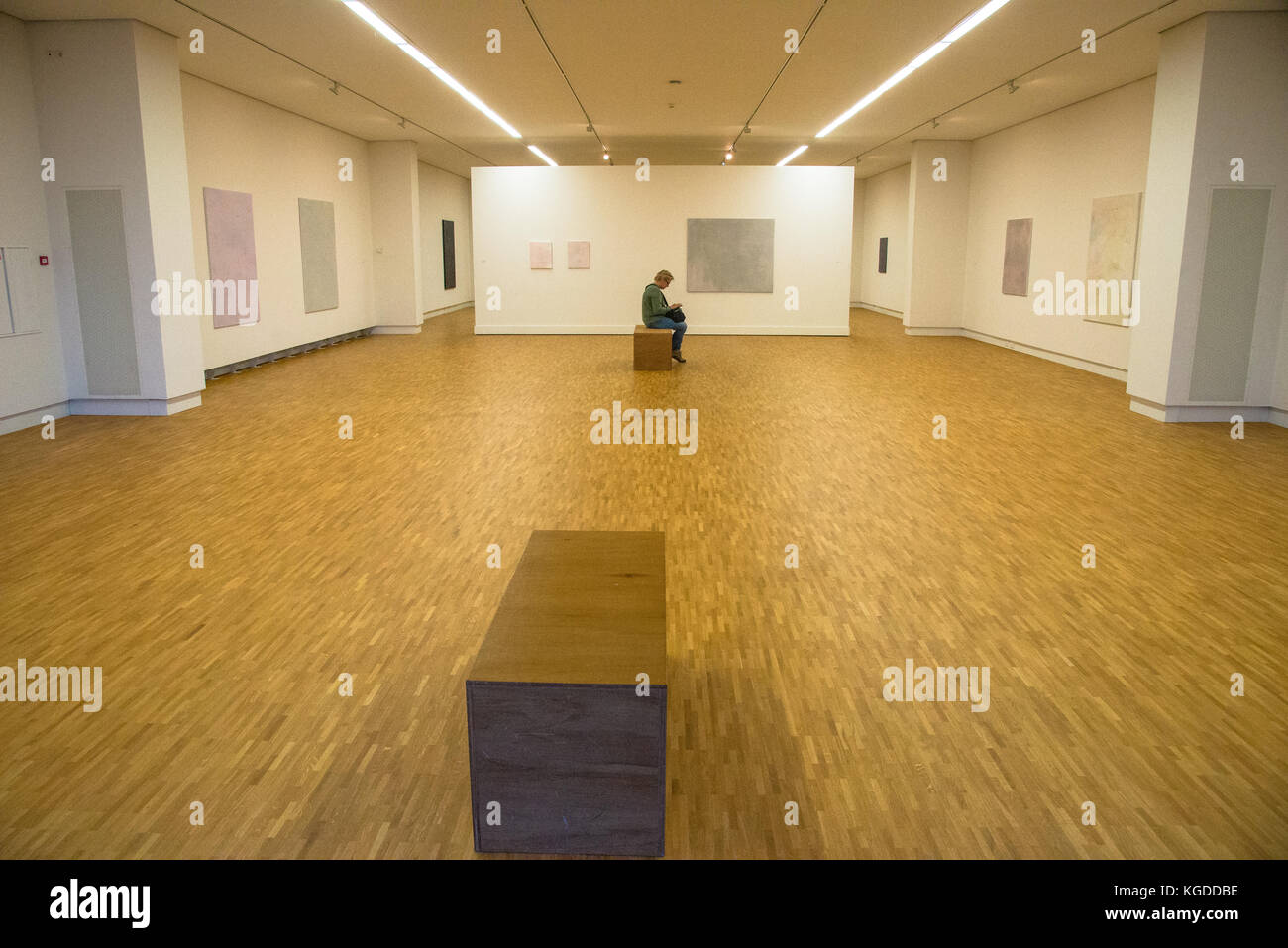 one vistor sitting in room with exposition of paintings of Maaike Schoorel at museum  in Den Haag, Holland Stock Photo