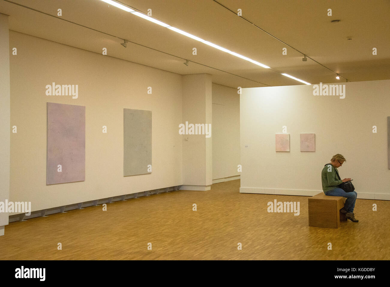 one vistor sitting in room with exposition of paintings of Maaike Schoorel at museum  in Den Haag, Holland Stock Photo
