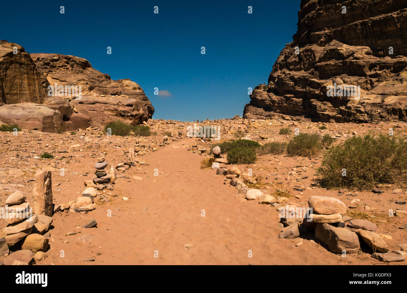 Sandy path lined with inukshuks or stone cairns leading to mountain top, Ad Deir, Petra, Jordan, Middle East Stock Photo