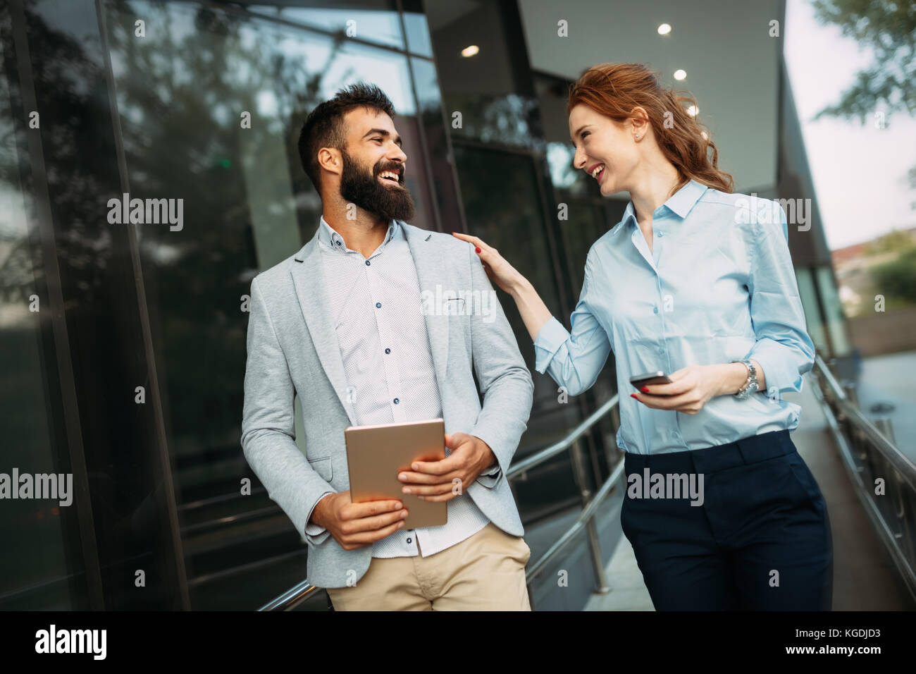Young business couple walking outdoor near office building Stock Photo ...
